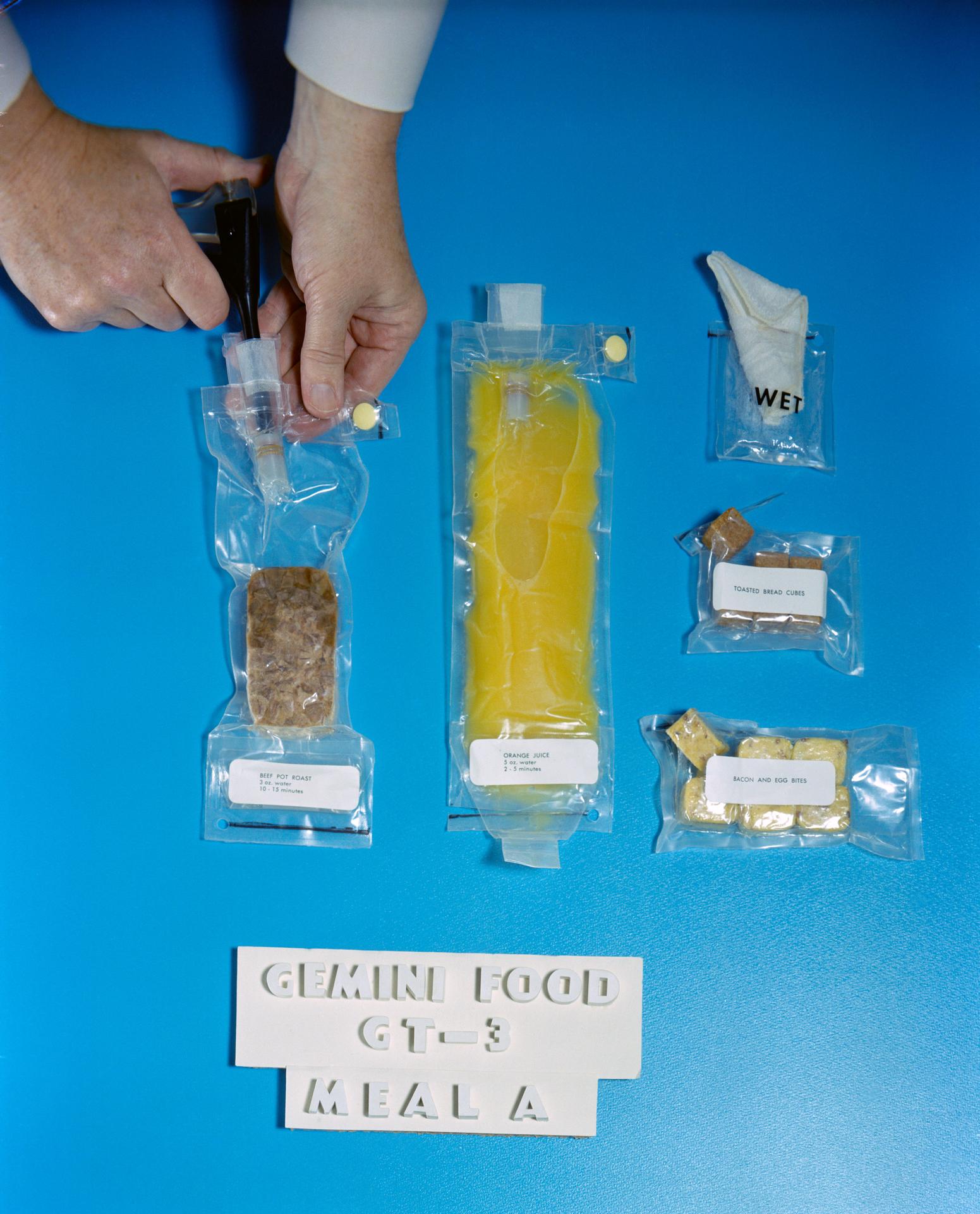 An array of food items in clear plastic packaging is shown on a blue background